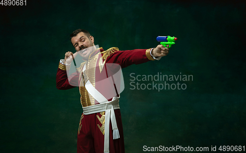 Image of Young man as Nicholas II on dark green background. Retro style, comparison of eras concept.