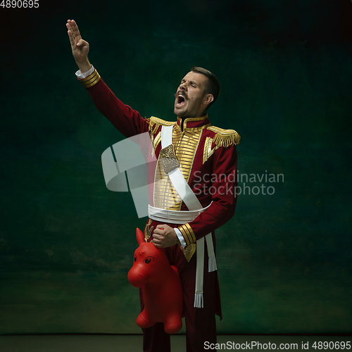 Image of Young man as Nicholas II on dark green background. Retro style, comparison of eras concept.