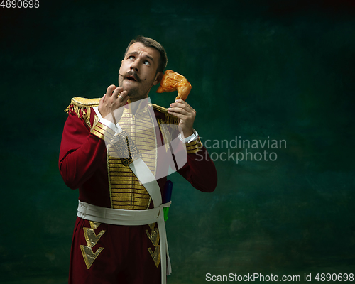 Image of Young man as Nicholas II on dark green background. Retro style, comparison of eras concept.