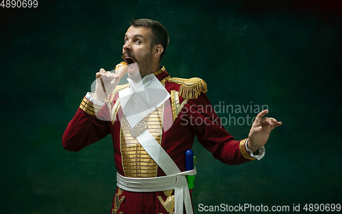 Image of Young man as Nicholas II on dark green background. Retro style, comparison of eras concept.