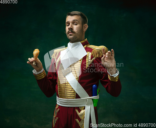 Image of Young man as Nicholas II on dark green background. Retro style, comparison of eras concept.