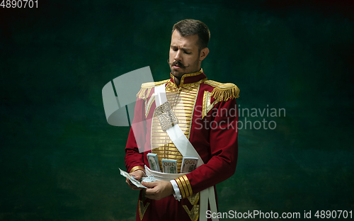Image of Young man as Nicholas II on dark green background. Retro style, comparison of eras concept.