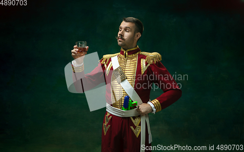 Image of Young man as Nicholas II on dark green background. Retro style, comparison of eras concept.