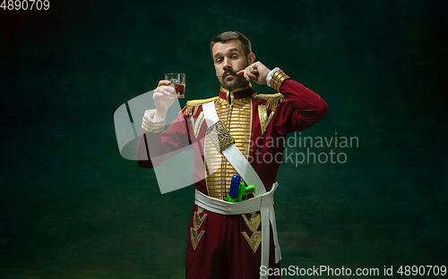 Image of Young man as Nicholas II on dark green background. Retro style, comparison of eras concept.