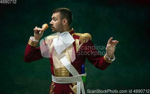 Image of Young man as Nicholas II on dark green background. Retro style, comparison of eras concept.