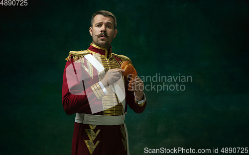 Image of Young man as Nicholas II on dark green background. Retro style, comparison of eras concept.