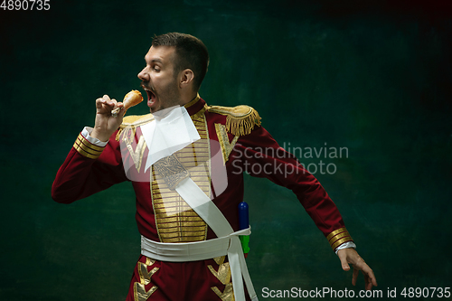 Image of Young man as Nicholas II on dark green background. Retro style, comparison of eras concept.