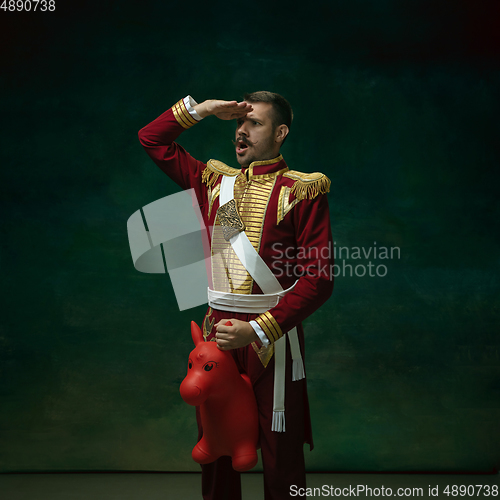 Image of Young man as Nicholas II on dark green background. Retro style, comparison of eras concept.