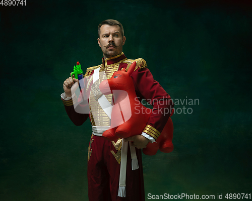 Image of Young man as Nicholas II on dark green background. Retro style, comparison of eras concept.