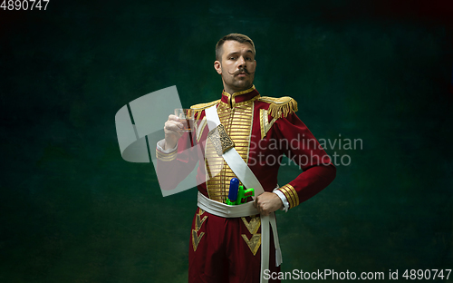 Image of Young man as Nicholas II on dark green background. Retro style, comparison of eras concept.