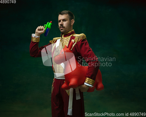 Image of Young man as Nicholas II on dark green background. Retro style, comparison of eras concept.