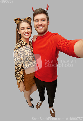 Image of happy couple in halloween costumes taking selfie