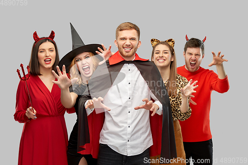 Image of friends in halloween costumes scaring