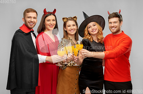 Image of happy friends in halloween costumes over grey