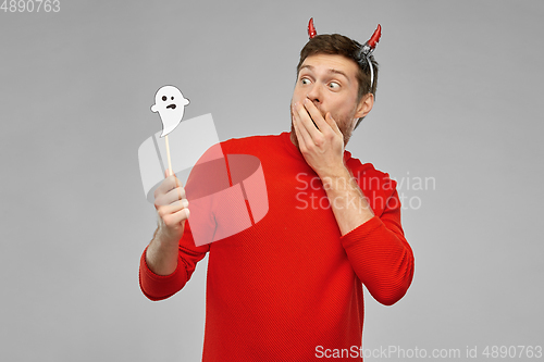 Image of man in halloween costume of devil over grey