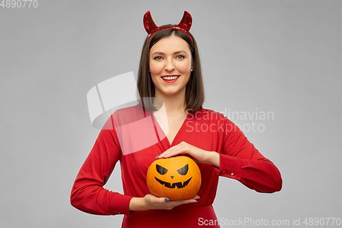 Image of woman in halloween costume of devil with pumpkin