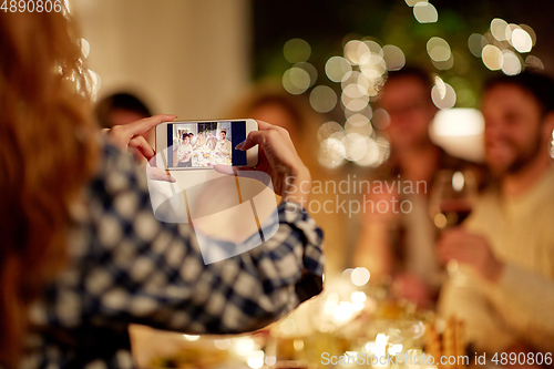 Image of friends photographing at christmas dinner party