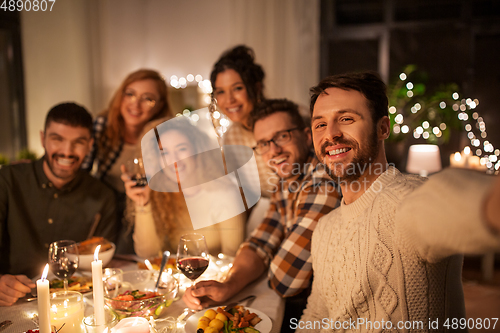 Image of friends taking selfie at christmas dinner party