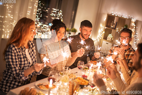 Image of happy friends having christmas dinner at home