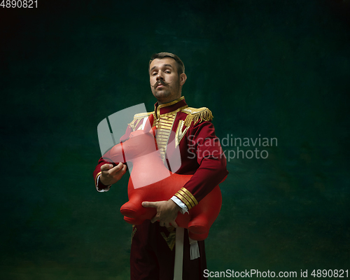 Image of Young man as Nicholas II on dark green background. Retro style, comparison of eras concept.