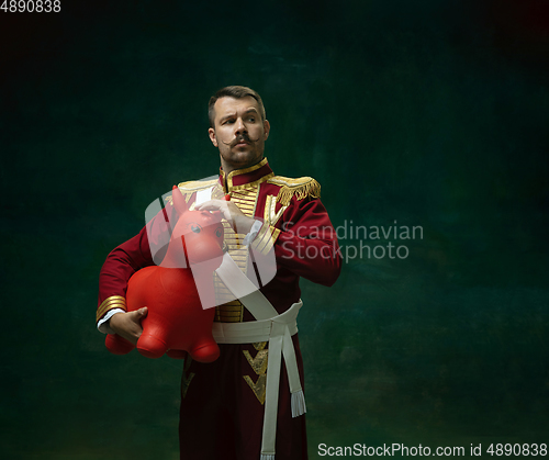 Image of Young man as Nicholas II on dark green background. Retro style, comparison of eras concept.