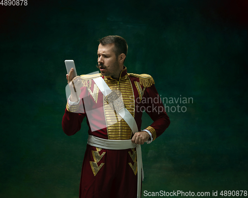 Image of Young man as Nicholas II on dark green background. Retro style, comparison of eras concept.