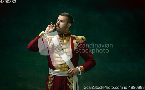 Image of Young man as Nicholas II on dark green background. Retro style, comparison of eras concept.