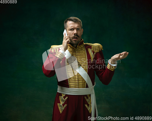 Image of Young man as Nicholas II on dark green background. Retro style, comparison of eras concept.