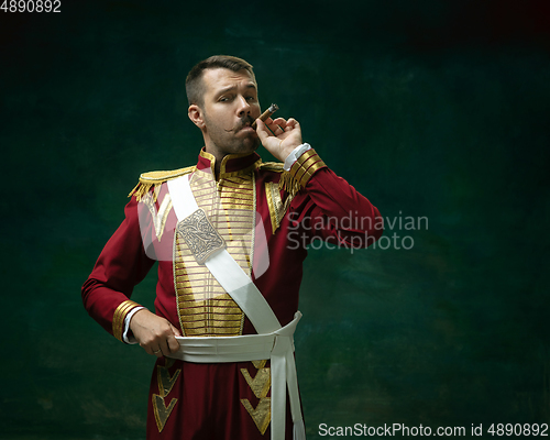 Image of Young man as Nicholas II on dark green background. Retro style, comparison of eras concept.