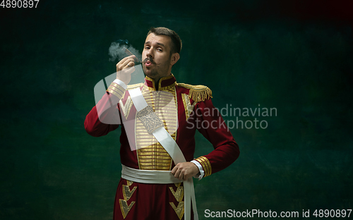 Image of Young man as Nicholas II on dark green background. Retro style, comparison of eras concept.