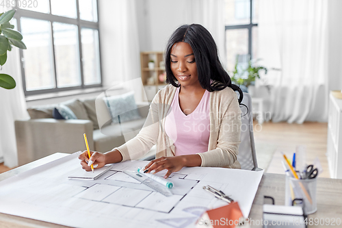 Image of female architect with house model and blueprint