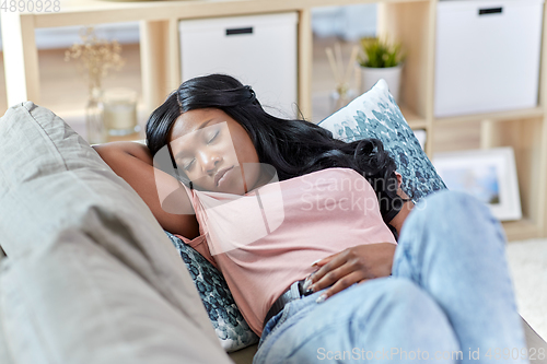 Image of african american woman sleeping on sofa at home