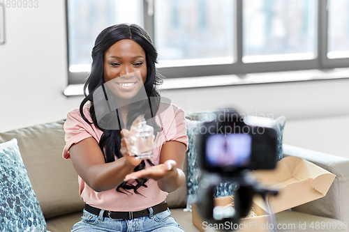 Image of female beauty blogger with camera and perfume