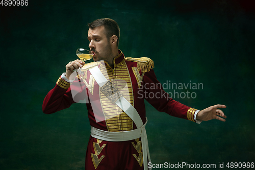 Image of Young man as Nicholas II on dark green background. Retro style, comparison of eras concept.