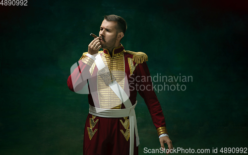 Image of Young man as Nicholas II on dark green background. Retro style, comparison of eras concept.