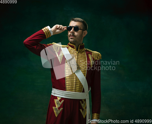 Image of Young man as Nicholas II on dark green background. Retro style, comparison of eras concept.