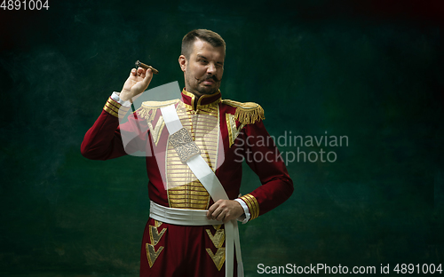 Image of Young man as Nicholas II on dark green background. Retro style, comparison of eras concept.