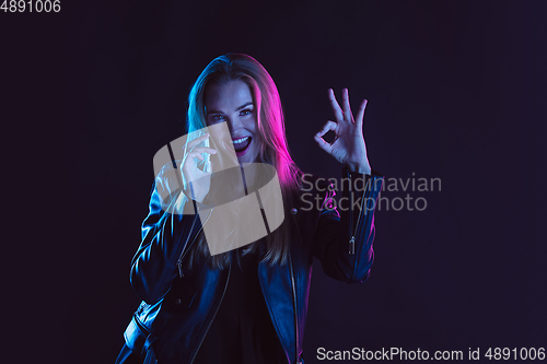 Image of Portrait of young woman in neon light on dark backgound. The human emotions, black friday, cyber monday, purchases, sales, finance concept.