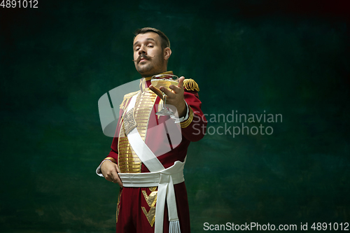 Image of Young man as Nicholas II on dark green background. Retro style, comparison of eras concept.