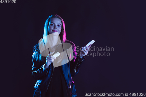 Image of Portrait of young woman in neon light on dark backgound. The human emotions, black friday, cyber monday, purchases, sales, finance concept.