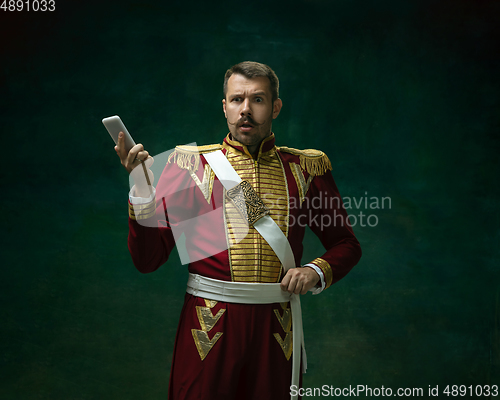 Image of Young man as Nicholas II on dark green background. Retro style, comparison of eras concept.