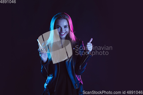 Image of Portrait of young woman in neon light on dark backgound. The human emotions, black friday, cyber monday, purchases, sales, finance concept.