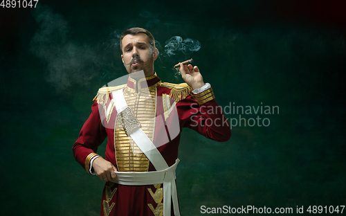 Image of Young man as Nicholas II on dark green background. Retro style, comparison of eras concept.