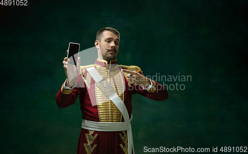 Image of Young man as Nicholas II on dark green background. Retro style, comparison of eras concept.