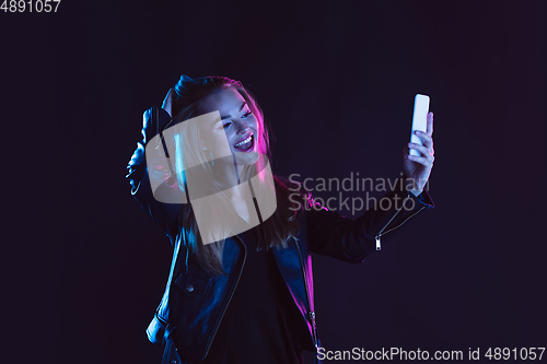 Image of Portrait of young woman in neon light on dark backgound. The human emotions, black friday, cyber monday, purchases, sales, finance concept.