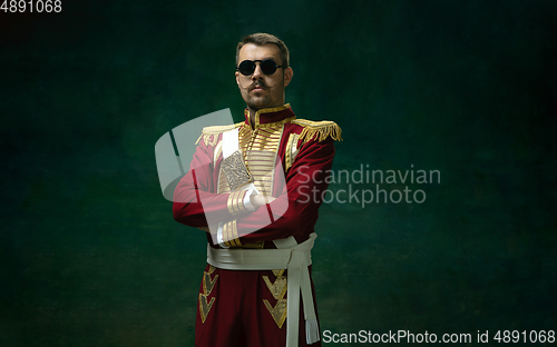 Image of Young man as Nicholas II on dark green background. Retro style, comparison of eras concept.