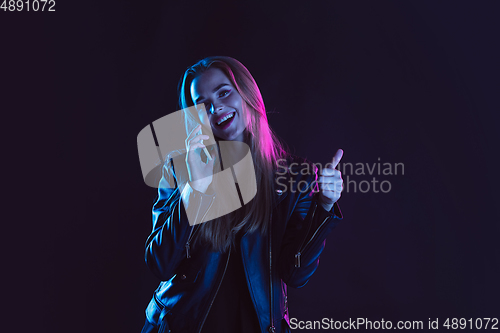 Image of Portrait of young woman in neon light on dark backgound. The human emotions, black friday, cyber monday, purchases, sales, finance concept.