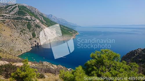 Image of Rocky beach, bue transparent sea with boats