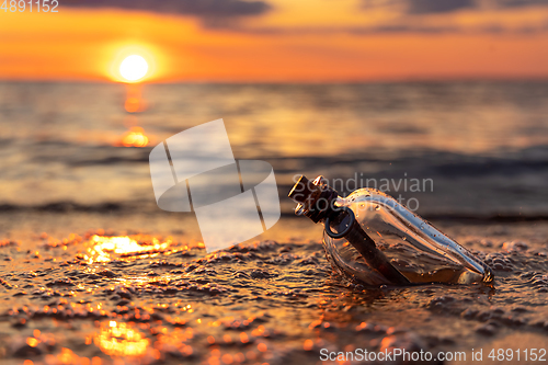 Image of Message in the bottle against the Sun setting down