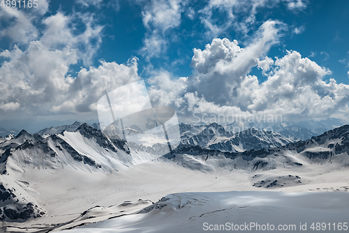 Image of Mountain clouds over beautiful snow-capped peaks of mountains an